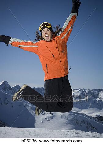 Woman jumping outside in the snow View Large Photo Image Stock Photograph - Woman jumping outside in the snow. Fotosearch