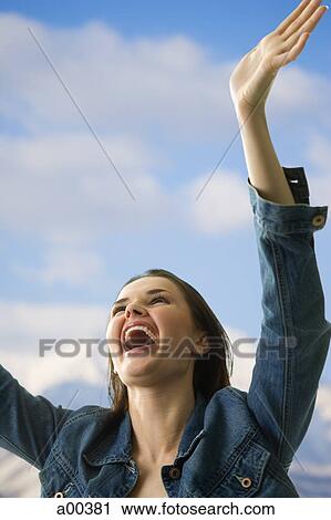 Woman laughing with arms raised View Large Photo Image Stock Image - Woman laughing with arms raised. Fotosearch