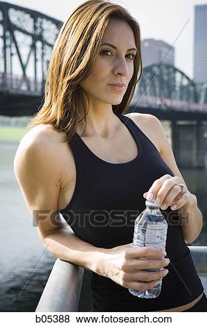 Woman leaning outdoors with bottled water View Large Photo Image Stock Photo - Woman leaning outdoors with bottled water. Fotosearch