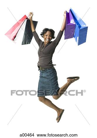 Picture - Woman leaping with gift bags. Fotosearch