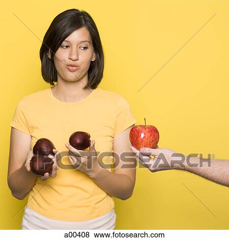 Woman looking at a hand with an apple View Large Photo Image Stock Photo - Woman looking at a hand with an apple. Fotosearch