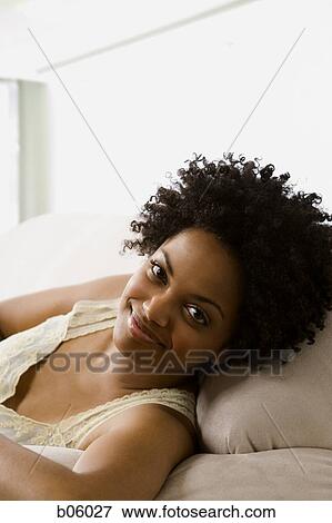 Stock Photo - Woman looking at the camera lying down. Fotosearch