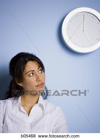 Woman looking at wall clock View Large Photo Image Stock Photo - Woman looking at wall clock. Fotosearch
