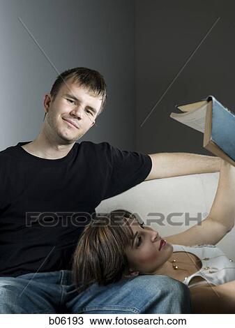 Woman lying in a man's lap reading View Large Photo Image Stock Image - Woman lying in a man's lap reading. Fotosearch