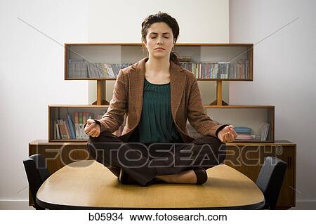 Woman meditating on a table View Large Photo Image Picture - Woman meditating on a table. Fotosearch