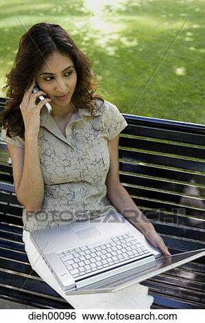 Stock Photograph - Woman on a laptop outside. Fotosearch