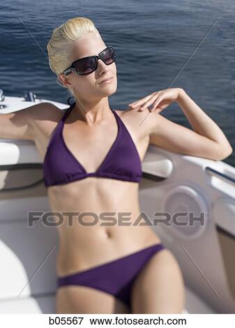 Woman on boat in bikini with sunglasses View Large Photo Image Stock Photo - Woman on boat in bikini with sunglasses. Fotosearch