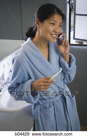 Woman on cell phone with toothbrush View Large Photo Image Stock Photo - Woman on cell phone with toothbrush. Fotosearch