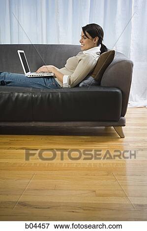 Woman on sofa with laptop View Large Photo Image Stock Photo - Woman on sofa with laptop. Fotosearch