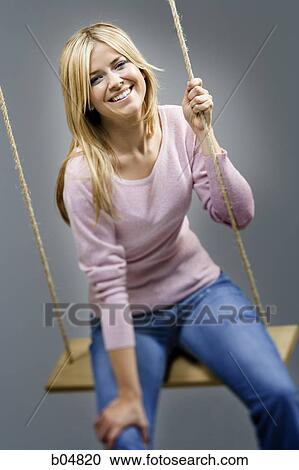 Stock Image - Woman on swing smiling. Fotosearch