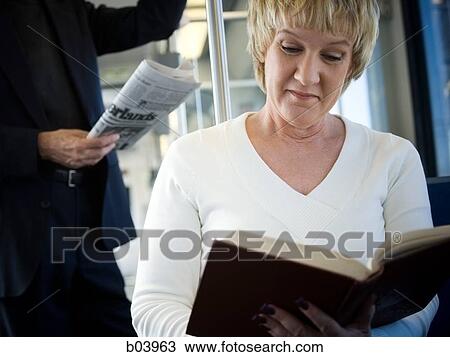 Woman reading on city bus or subway View Large Photo Image Stock Image - Woman reading on city bus or subway. Fotosearch