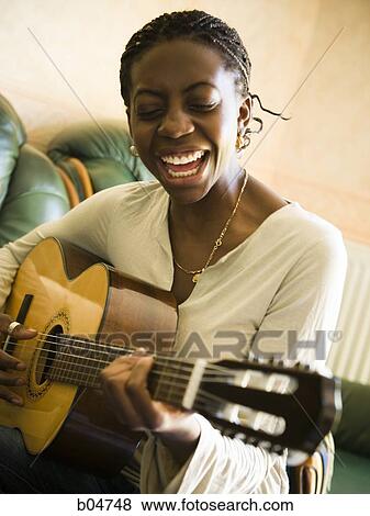 Woman singing and playing guitar View Large Photo Image Stock Photo - Woman singing and playing guitar. Fotosearch