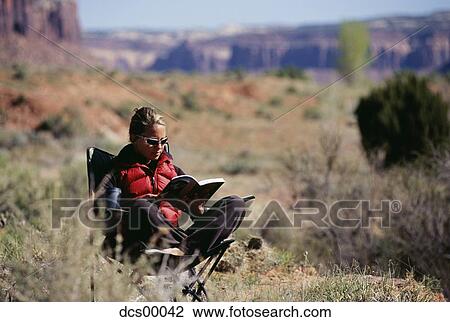 Woman sitting in chair in desert reading View Large Photo Image Stock Image - Woman sitting in chair in desert reading. Fotosearch