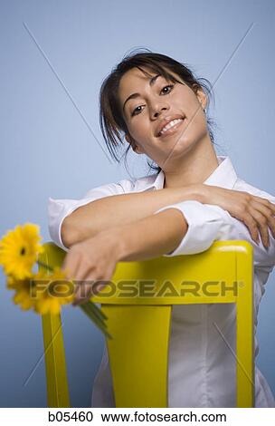 Woman sitting in yellow chair with flowers View Large Photo Image Stock Image - Woman sitting in yellow chair with flowers. Fotosearch