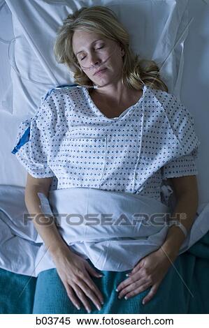 Stock Photography - Woman sleeping in hospital bed. Fotosearch