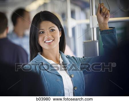Woman standing on city bus or subway View Large Photo Image Stock Image - Woman standing on city bus or subway. Fotosearch