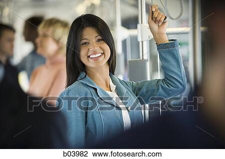 Woman standing on city bus or subway View Large Photo Image Stock Image - Woman standing on city bus or subway. Fotosearch