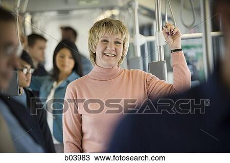 Woman standing on city bus or subway View Large Photo Image Stock Image - Woman standing on city bus or subway. Fotosearch