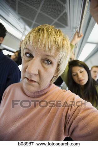 Woman standing on city bus or subway View Large Photo Image Stock Photo - Woman standing on city bus or subway. Fotosearch