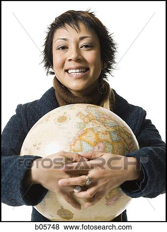 Woman standing with a globe View Large Photo Image Stock Photo - Woman standing with a globe. Fotosearch
