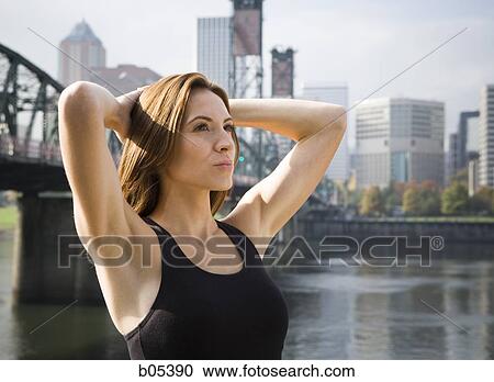 Woman standing with arms up outdoors city skyline View Large Photo Image Stock Image - Woman standing with arms up outdoors city skyline. Fotosearch