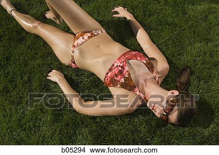 Woman sunbathing on grass View Large Photo Image Picture - Woman sunbathing on grass. Fotosearch