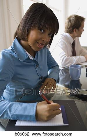 Woman taking notes at business meeting View Large Photo Image Stock Image - Woman taking notes at business meeting. Fotosearch