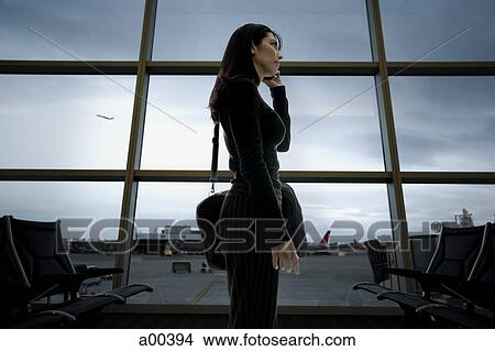 Woman talking on phone at airport View Large Photo Image Picture - Woman talking on phone at airport. Fotosearch