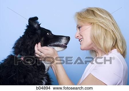 Woman talking to dog and smiling View Large Photo Image Picture - Woman talking to dog and smiling. Fotosearch