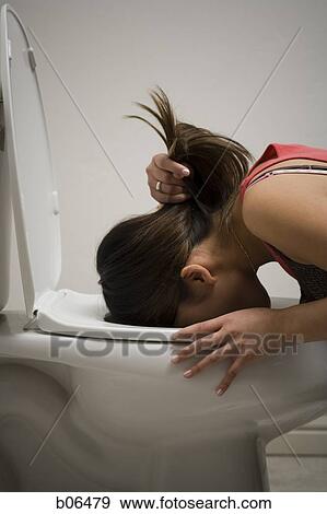 Stock Photo - Woman throwing up into the toilet. Fotosearch