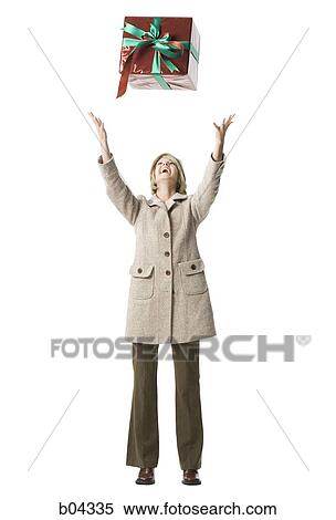 Woman tossing gift box in the air View Large Photo Image Stock Photography - Woman tossing gift box in the air. Fotosearch
