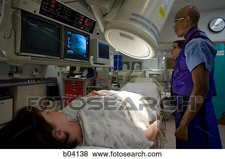 Stock Photo - Woman undergoing x-ray in lab. Fotosearch