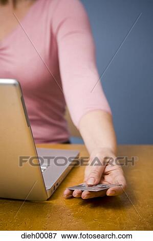 Woman using her credit card on her computer View Large Photo Image Stock Photo - Woman using her credit card on her computer. Fotosearch