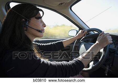 Woman wearing earphone driving car View Large Photo Image Stock Image - Woman wearing earphone driving car. Fotosearch