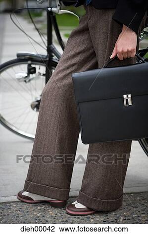 Woman with bicycle and briefcase View Large Photo Image Stock Image - Woman with bicycle and briefcase. Fotosearch