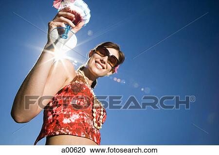Woman with cocktail and sunglasses outdoors smiling View Large Photo Image Stock Image - Woman with cocktail and sunglasses outdoors smiling. Fotosearch