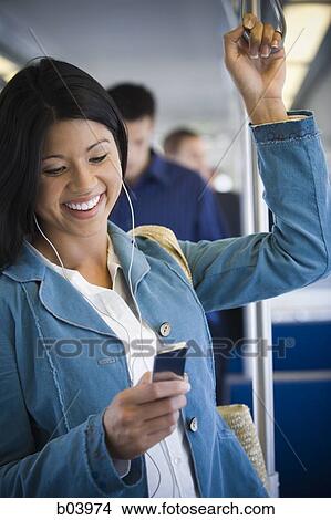 Woman with iPod on city bus or subway View Large Photo Image Picture - Woman with iPod on city bus or subway. Fotosearch
