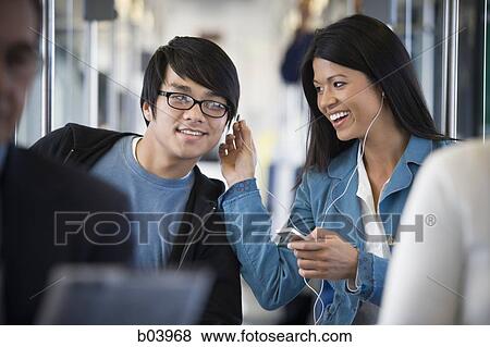Stock Photo - Woman with iPod talking to man on city bus or subway. Fotosearch