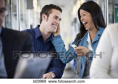 Woman with iPod talking to man on city bus or subway View Large Photo Image Stock Photo - Woman with iPod talking to man on city bus or subway. Fotosearch