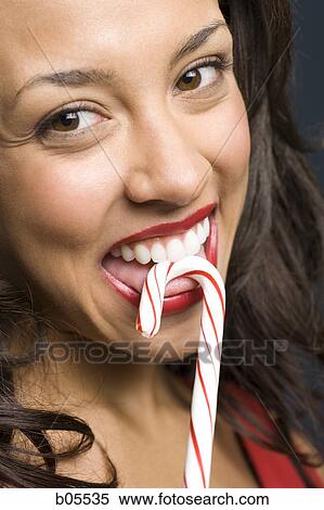 Woman with red lipstick eating candy cane View Large Photo Image Stock Photography - Woman with red lipstick eating candy cane. Fotosearch