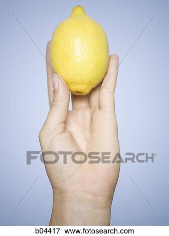 Stock Photo - Woman's hand with lemon. Fotosearch