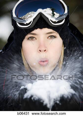 Young adult woman outside blowing snow View Large Photo Image Stock Image - Young adult woman outside blowing snow. Fotosearch