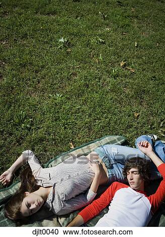 Young couple laying outdoors View Large Photo Image Stock Image - Young couple laying outdoors. Fotosearch