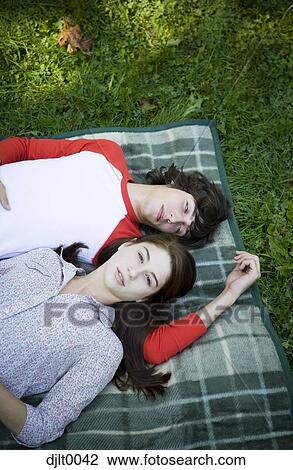 Stock Image - Young couple laying outdoors. Fotosearch