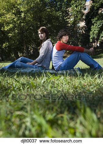 Young couple sitting outdoors View Large Photo Image Stock Photo - Young couple sitting outdoors. Fotosearch