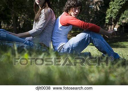Young couple sitting outdoors View Large Photo Image Stock Photo - Young couple sitting outdoors. Fotosearch