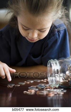 Young girl counting coins from jar View Large Photo Image Stock Photo - Young girl counting coins from jar. Fotosearch