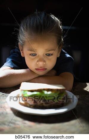 Young girl looking at sandwich sulking View Large Photo Image Stock Photograph - Young girl looking at sandwich sulking. Fotosearch