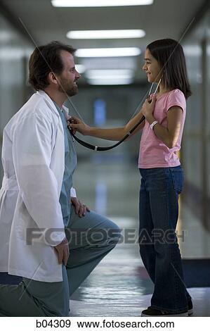 Stock Photo - Young girl playing with female doctor's stethoscope. Fotosearch