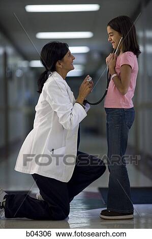 Stock Photograph - Young girl playing with female doctor's stethoscope. Fotosearch